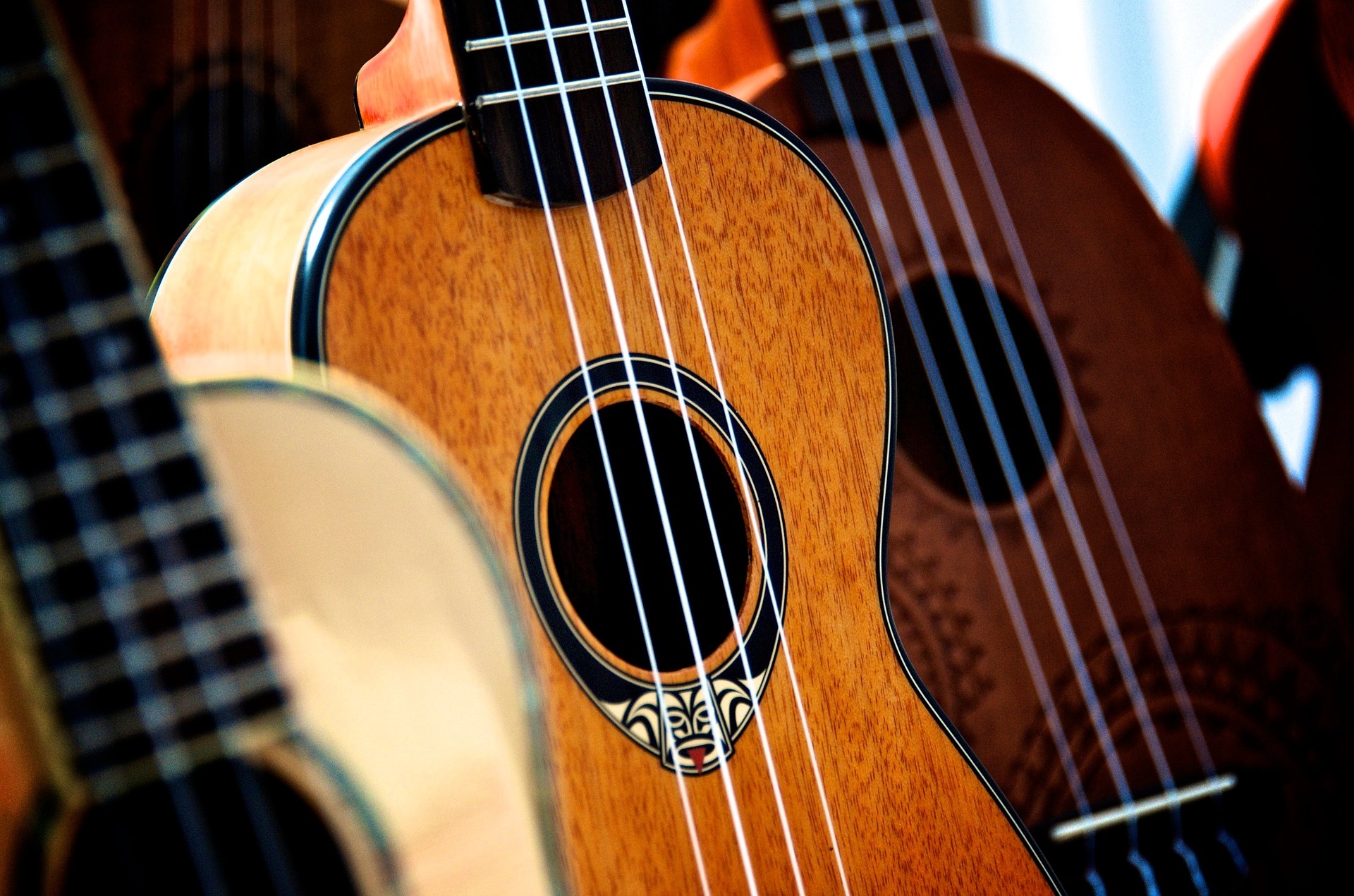 Three ukuleles. Only the bodies of the instruments are visible.
