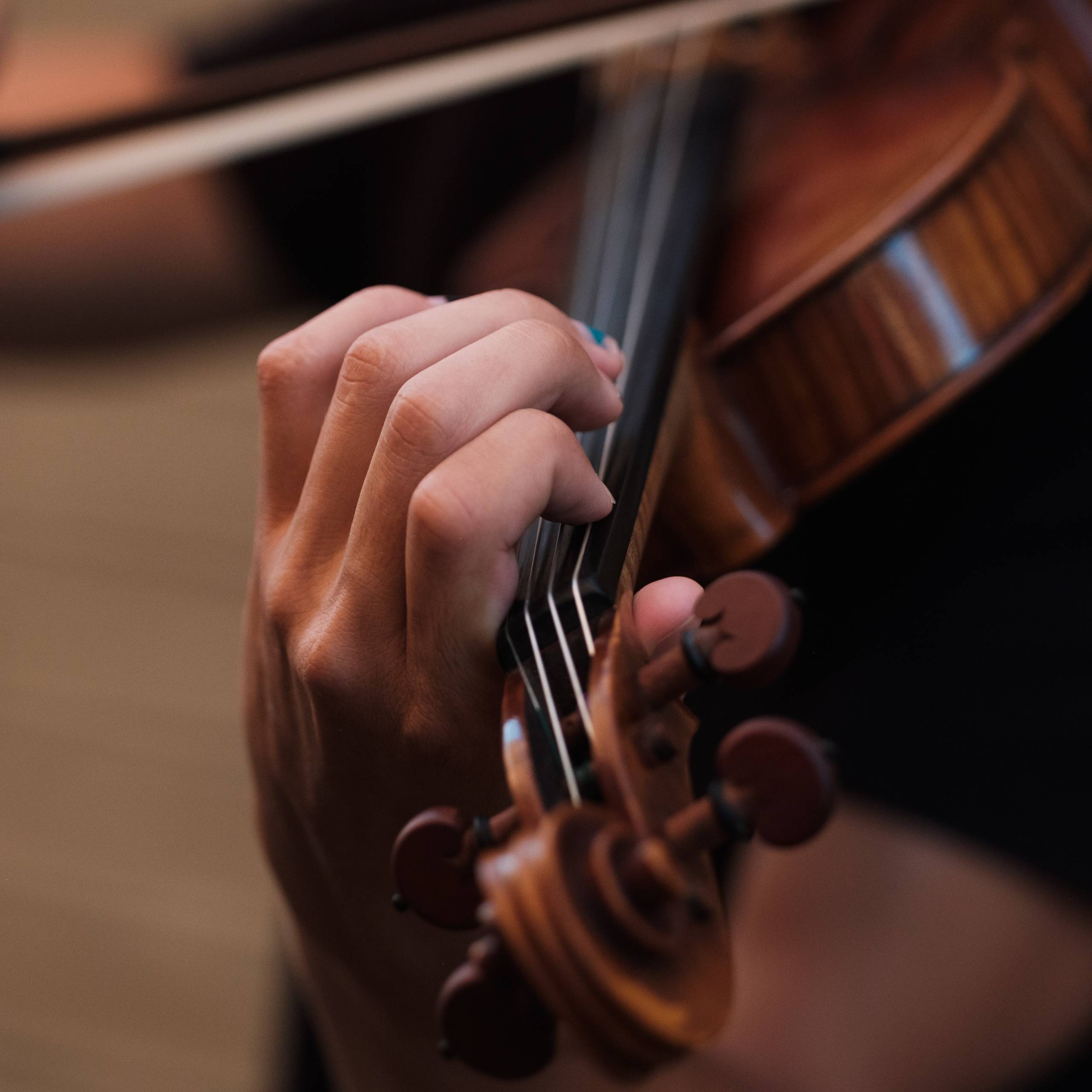 A close up of a hand playing a violin